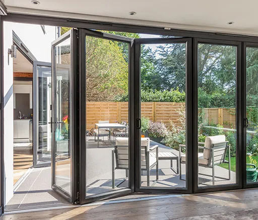 Luxora multi-panel glass door system opening from interior to a garden patio